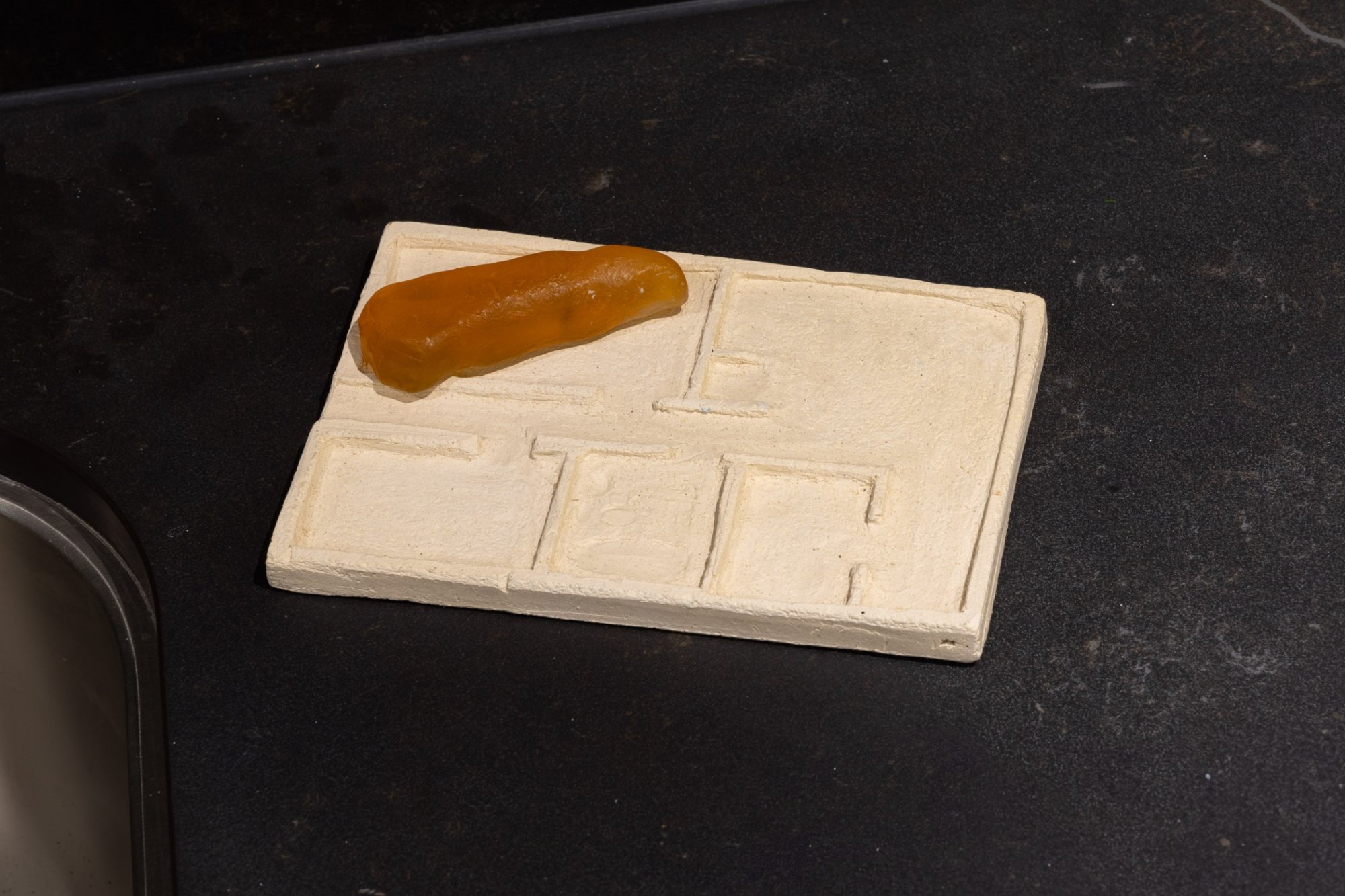 Plaster floorplan soap dish with thumb shaped soap.